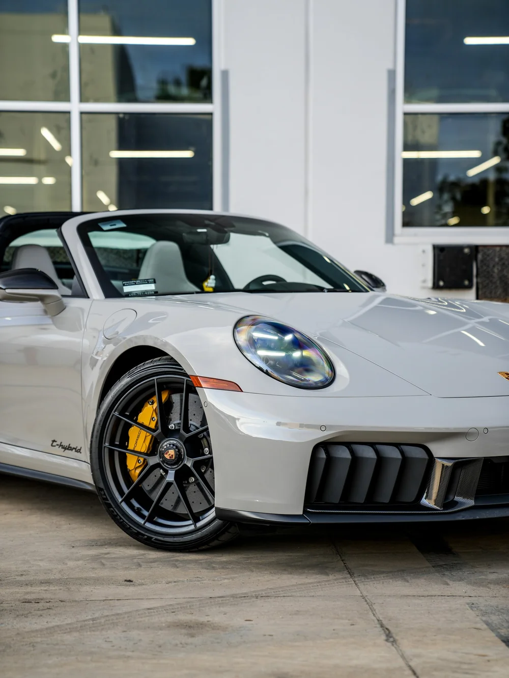 Porsche Targa front wheel, yellow brake caliper and oval headlight in a close front-corner view
