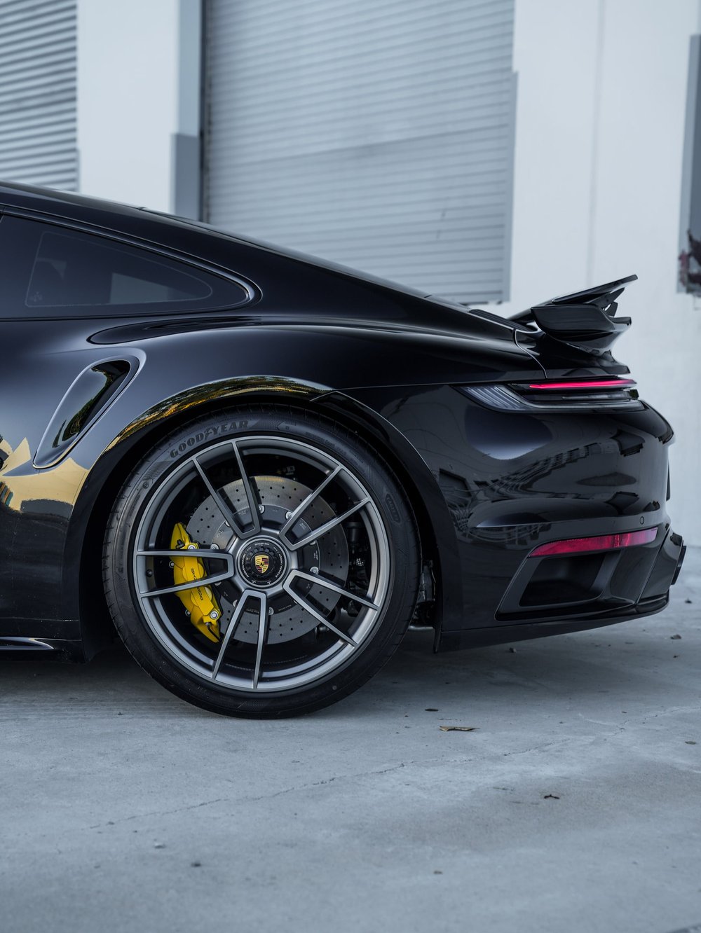 Porsche 911 Turbo S rear wheel, quarter panel and raised spoiler viewed from the side
