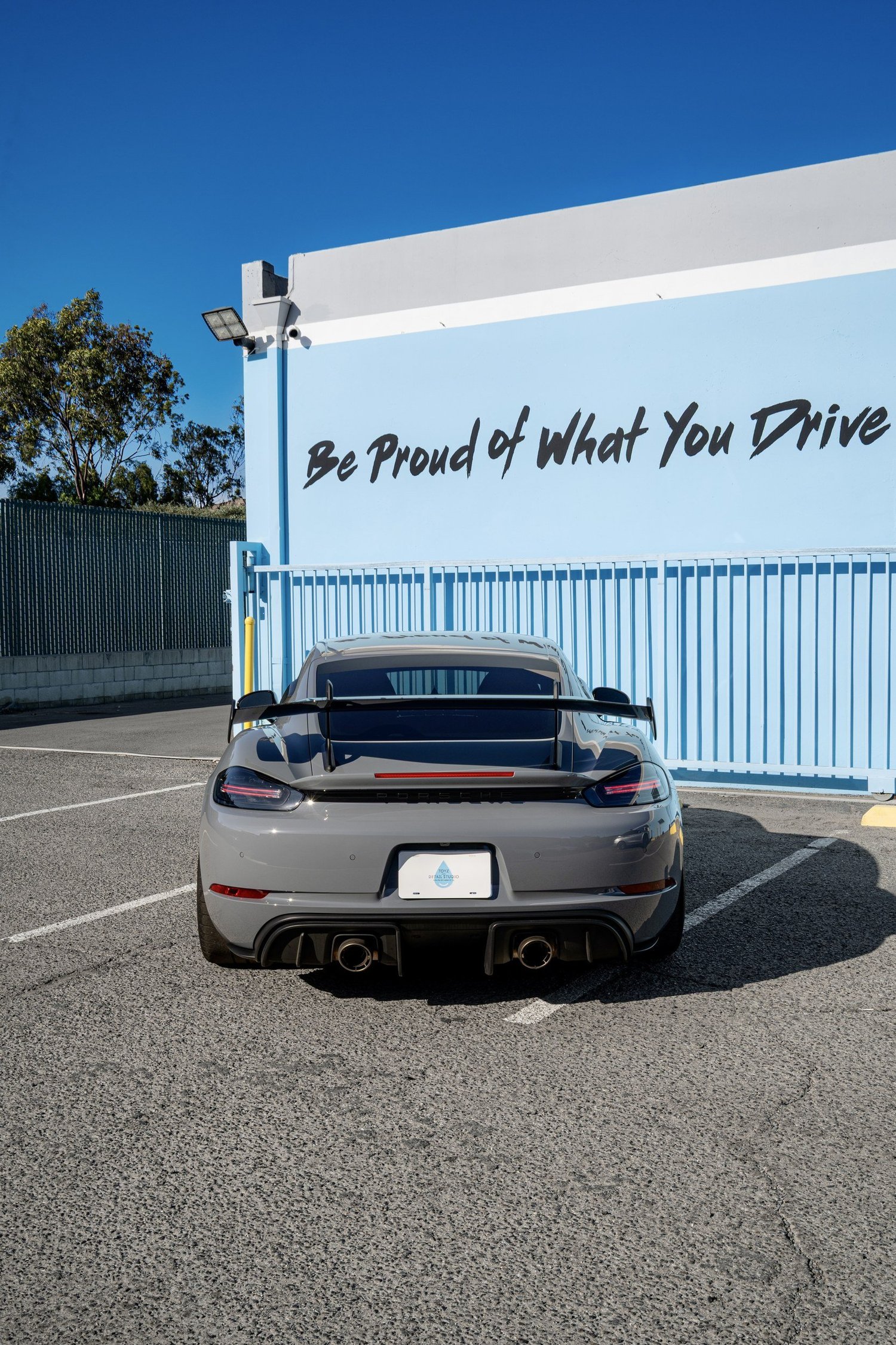 Straight rear view of the Arctic Grey GT4 RS, showing its wing, rear hatch glass, taillights and twin exhaust outlets.