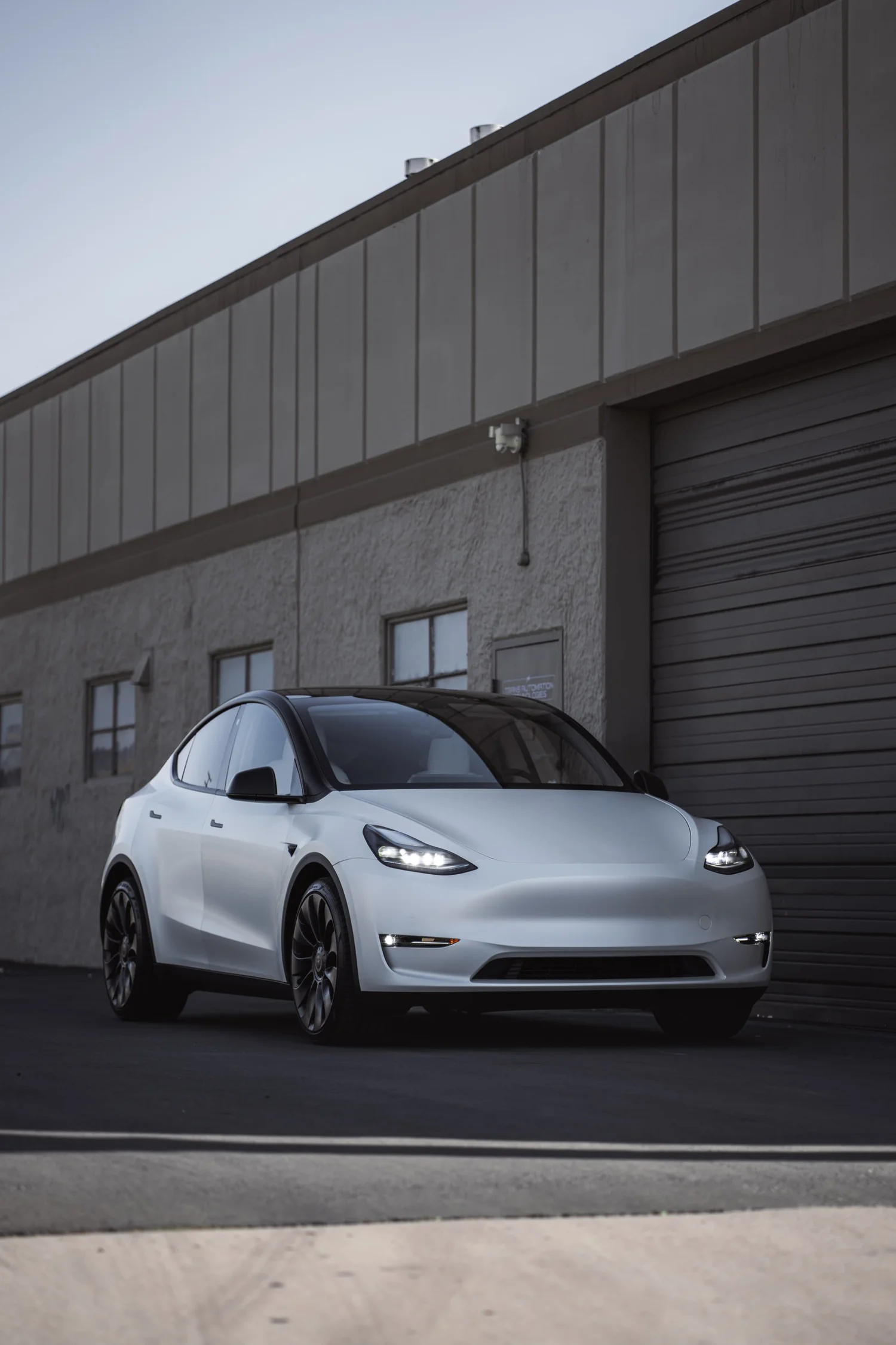 Satin Pearl White Tesla Model Y after Vinyl Wrap, front-left three-quarter view