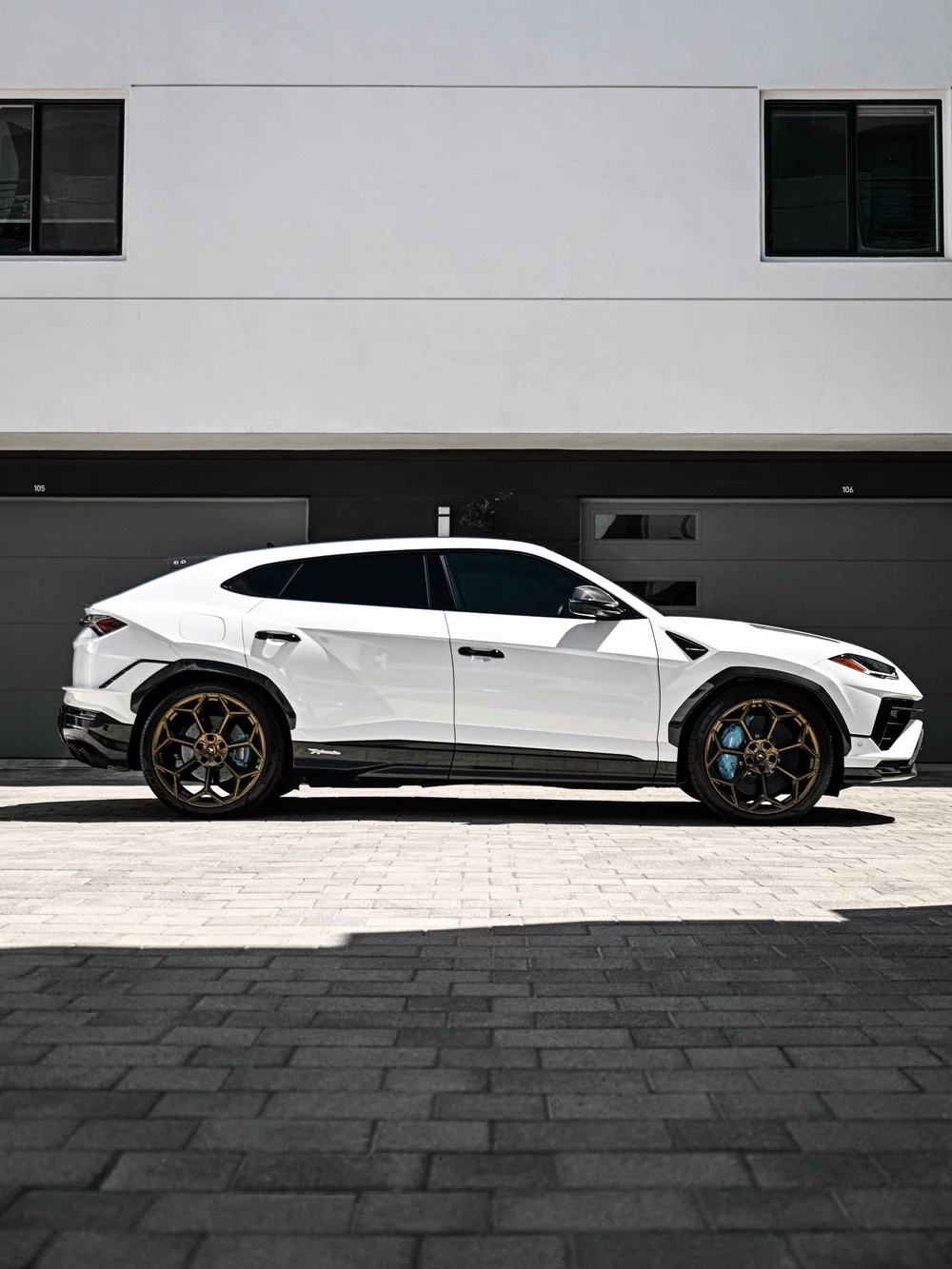 Complete side profile of the white Urus Performante with dark glass and bronze-toned wheels