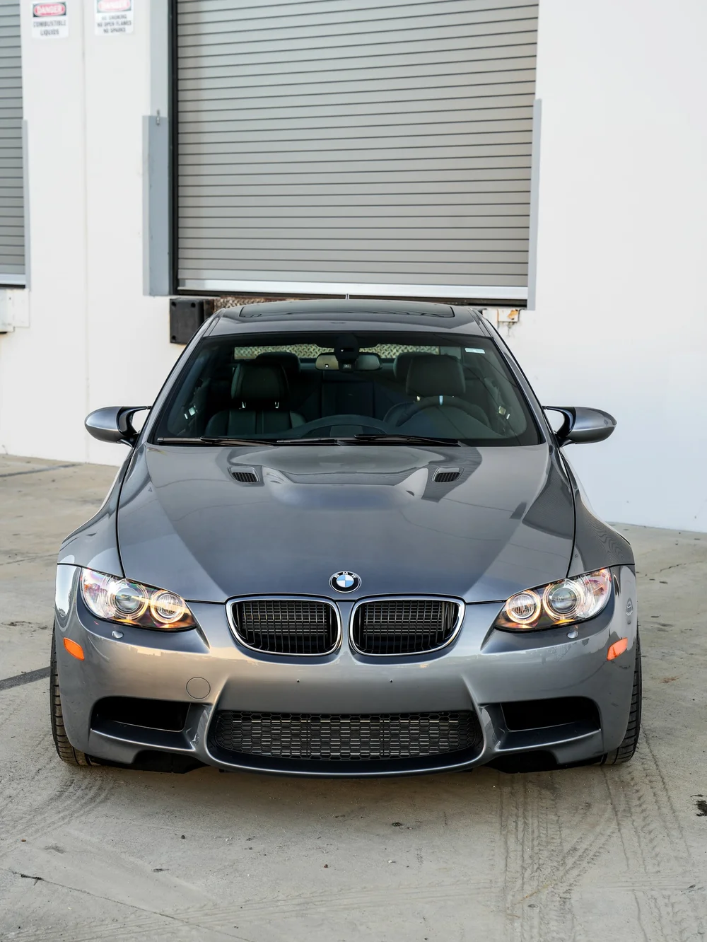 BMW E92 M3 paint protection film project, direct front view beside the studio roll-up door