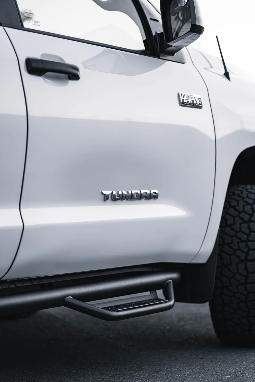 Gloss White Toyota Tundra door panel with the Tundra lettering and side step visible