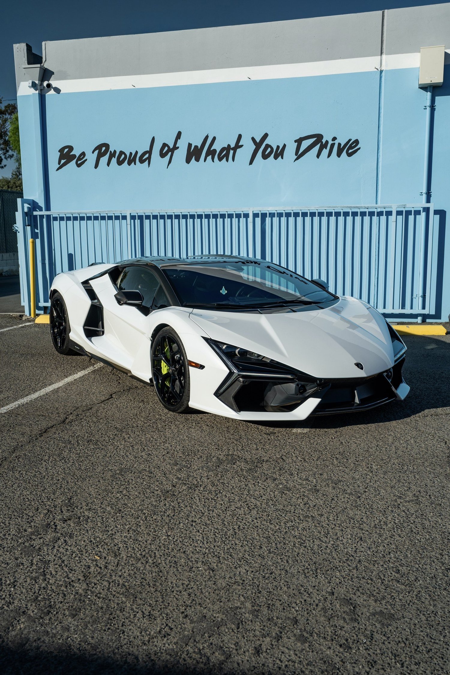 White Lamborghini Revuelto from the front three-quarter angle against the Toyz studio wall.