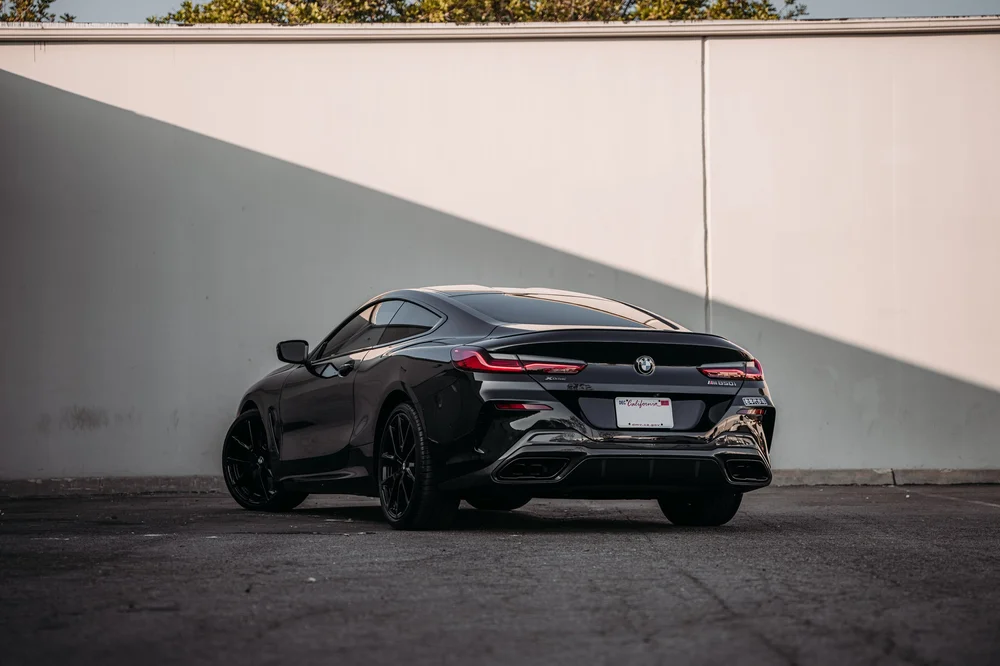 Wide rear three-quarter view of the BMW M850i showing the rear body and wheels