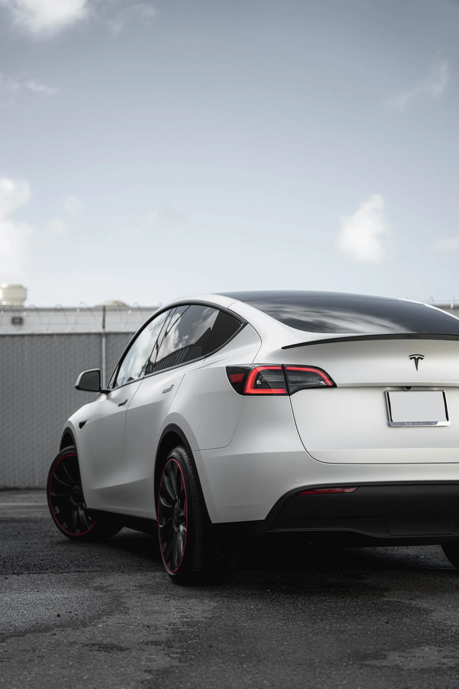 Satin Pearl White Tesla Model Y with Custom Exterior Accents after Vinyl Wrap, rear-right three-quarter view