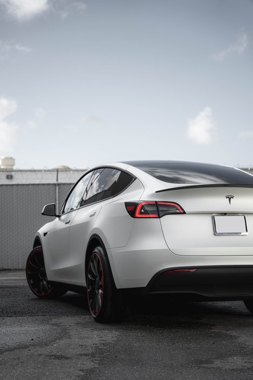 Satin Pearl White Tesla Model Y rear three-quarter photograph illustrating a vinyl wrap project