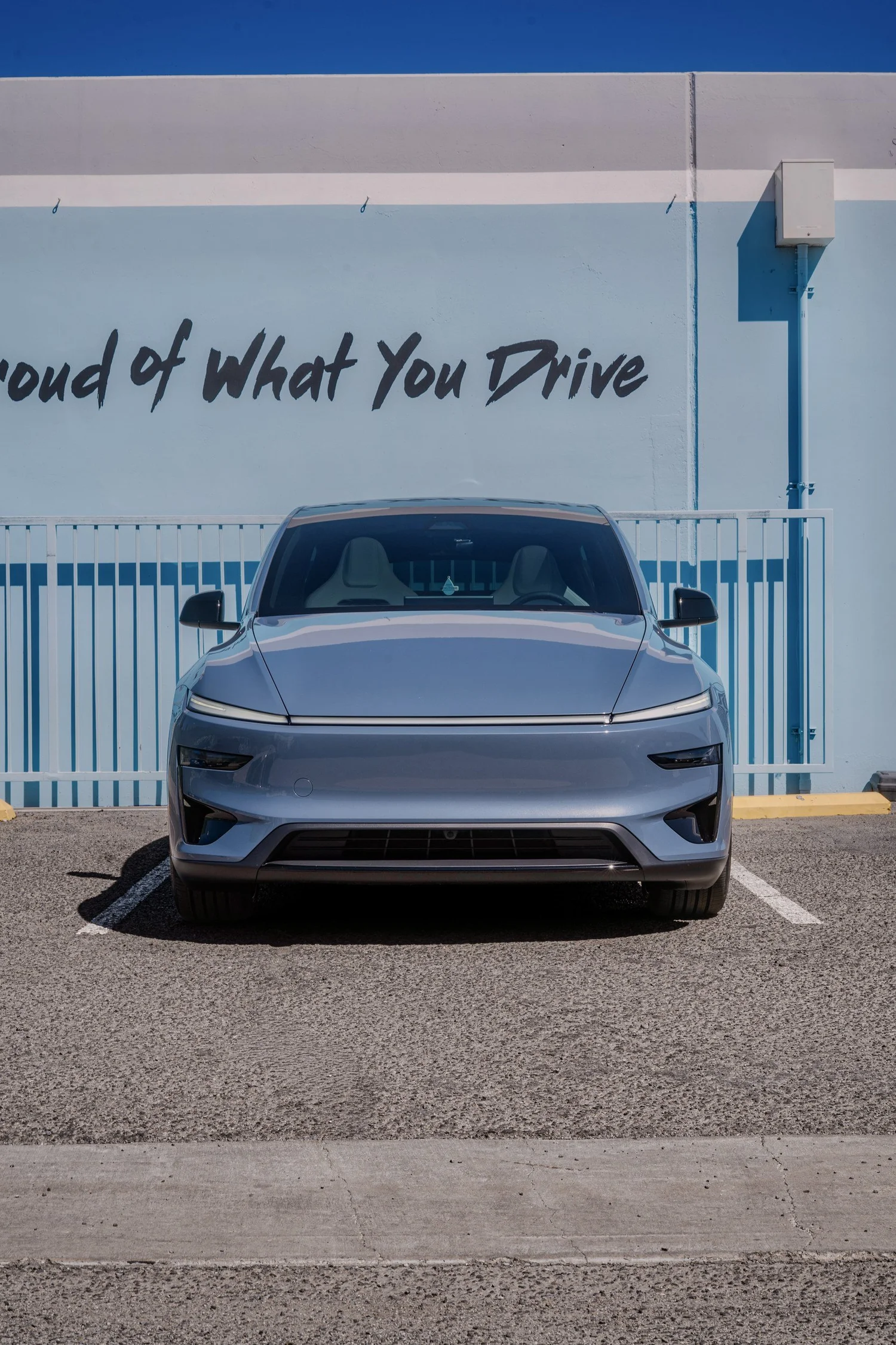 Front view of the Glacier Blue Model Y Performance with its white cabin visible through the windshield