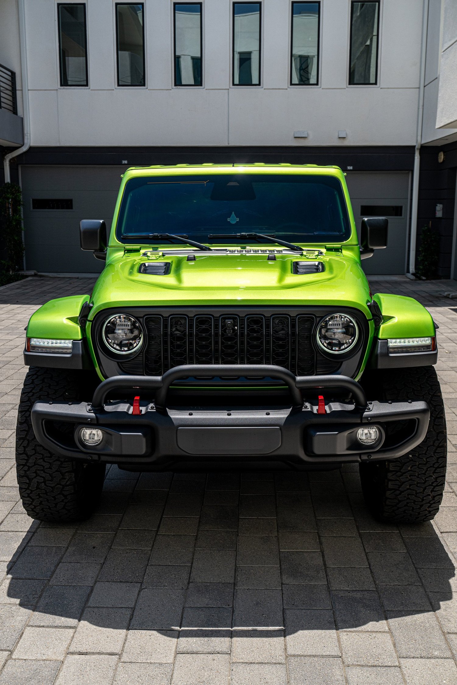 Straight front view of the 2026 Mojito Jeep Wrangler Rubicon with round headlights and a seven-slot grille