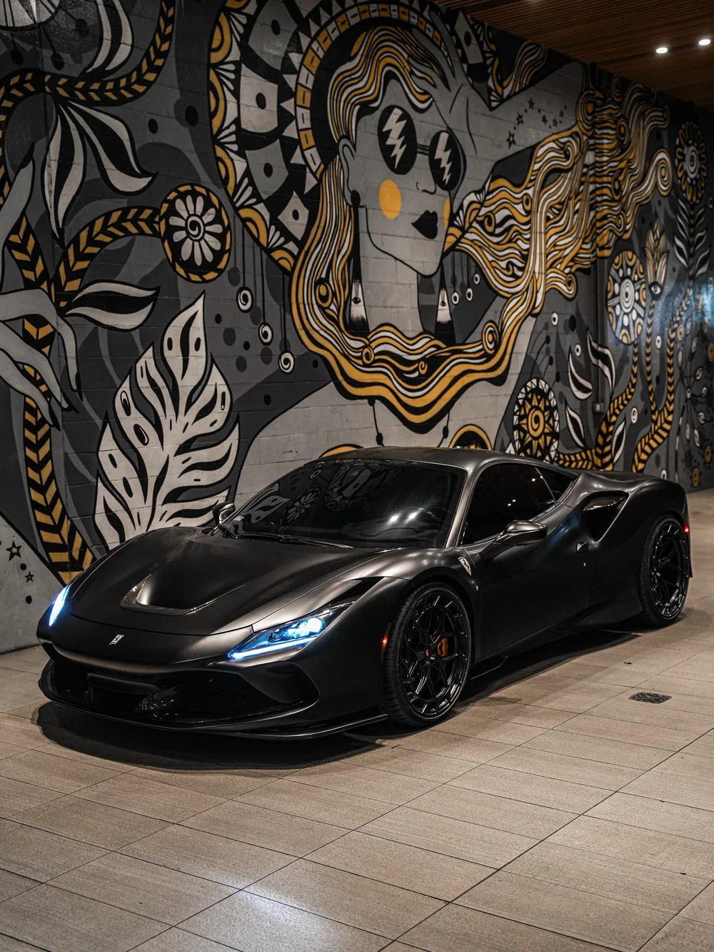 Full front three-quarter view beside a mural wall — Ferrari F8 3M Satin Black vinyl wrap project