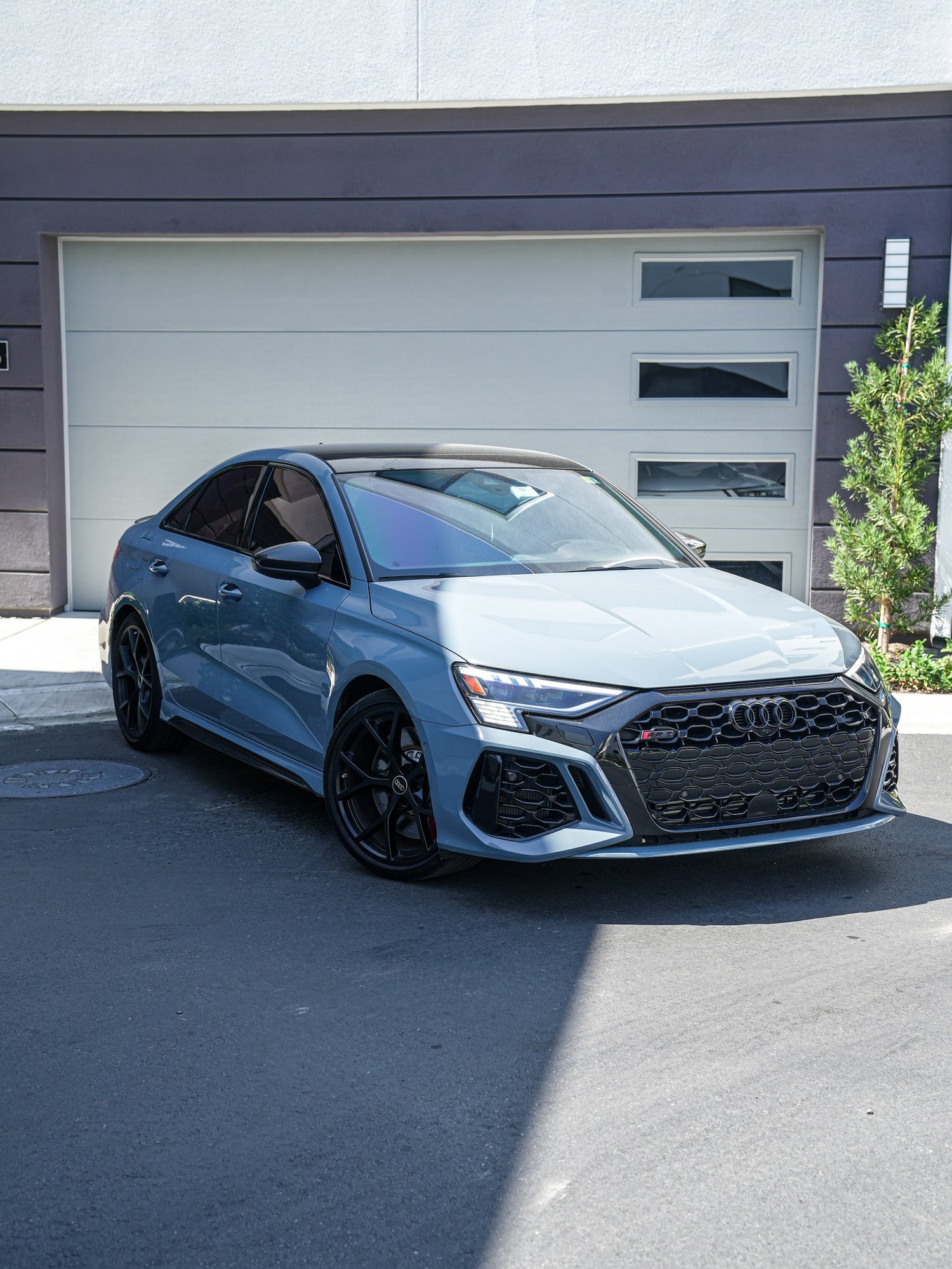 Blue-grey Audi RS 3 in a complete front three-quarter view with a dark grille and wheels