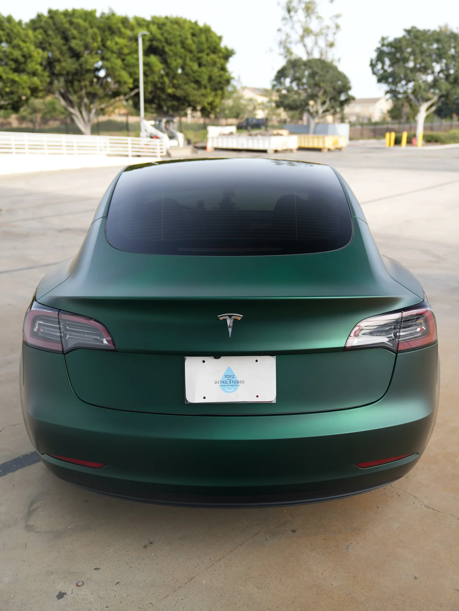 Tesla Model 3 Ghost Matte Green after Vinyl Wrap, low-angle rear view