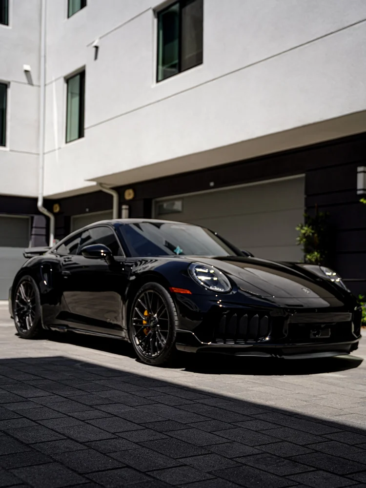 Low front three-quarter view of the Turbo S across sunlit paving.