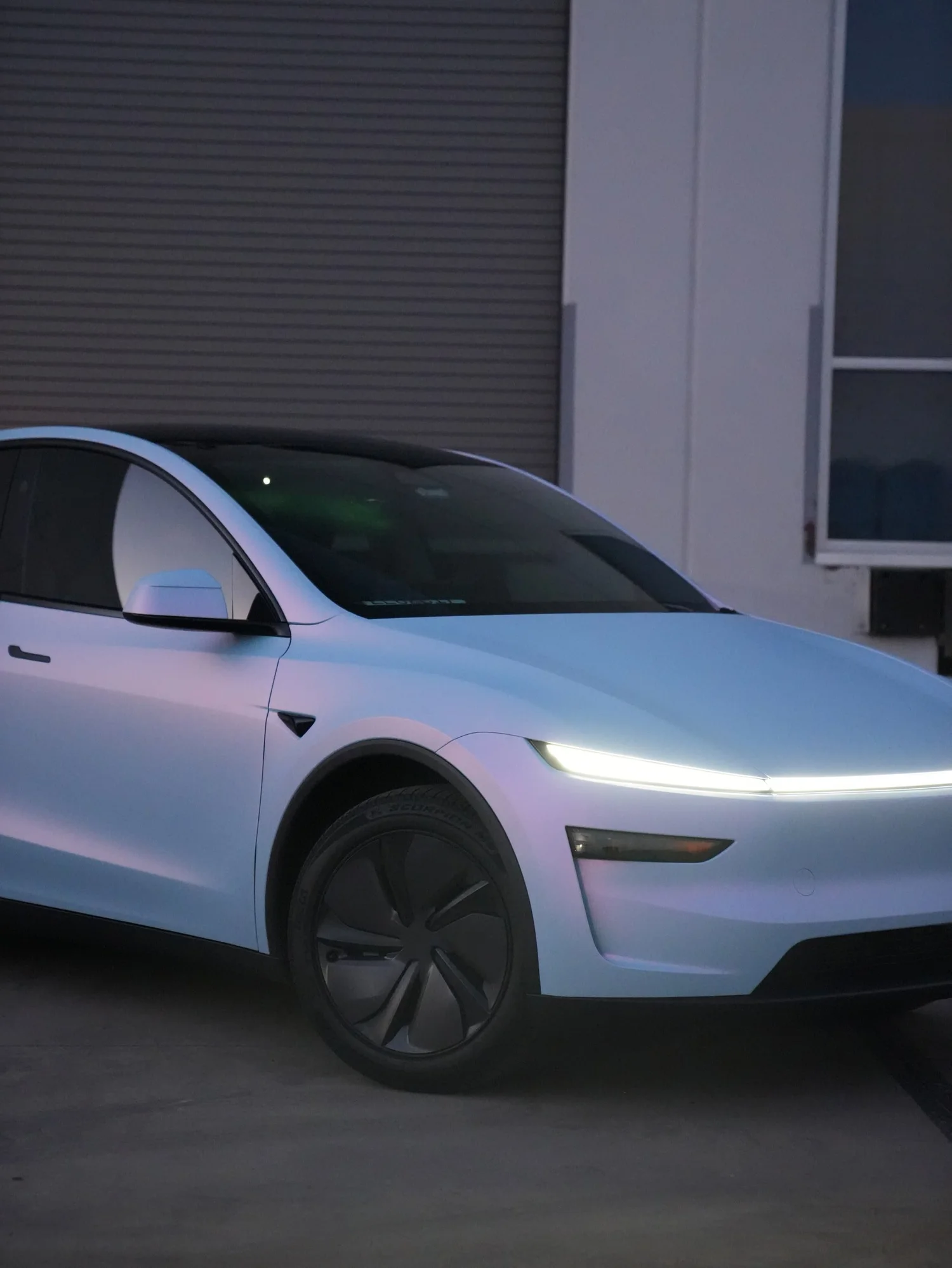 Tesla Model Y Color-Shifting White-to-Blue after Vinyl Wrap, front-left three-quarter view