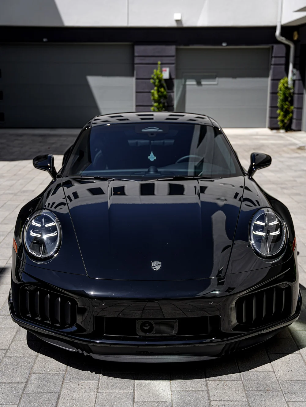 Straight-on front view of the Jet Black Metallic Turbo S, including the windshield and front bumper.