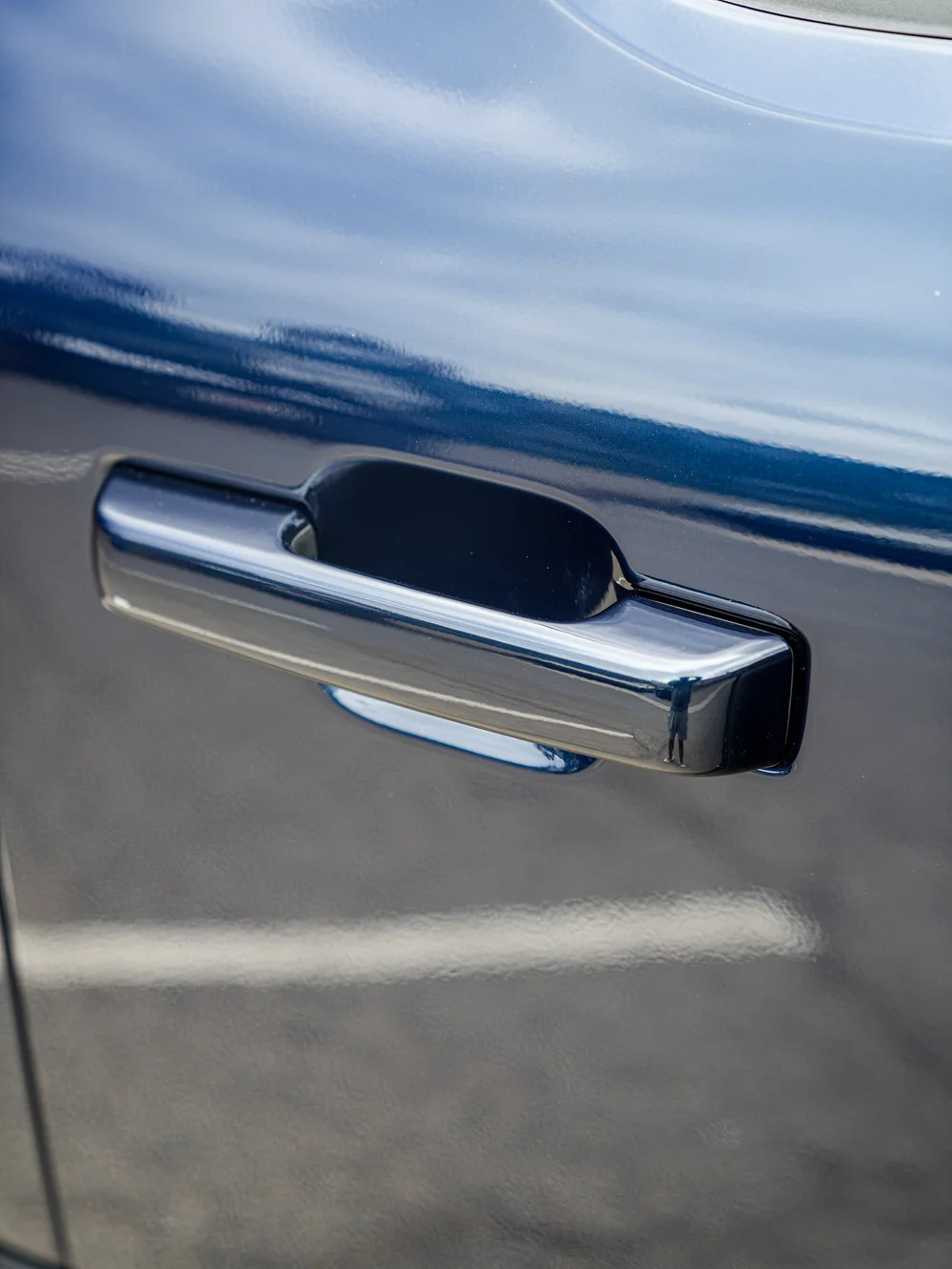 Dark Blue Ford F-150 Raptor, side door and handle with sky reflections