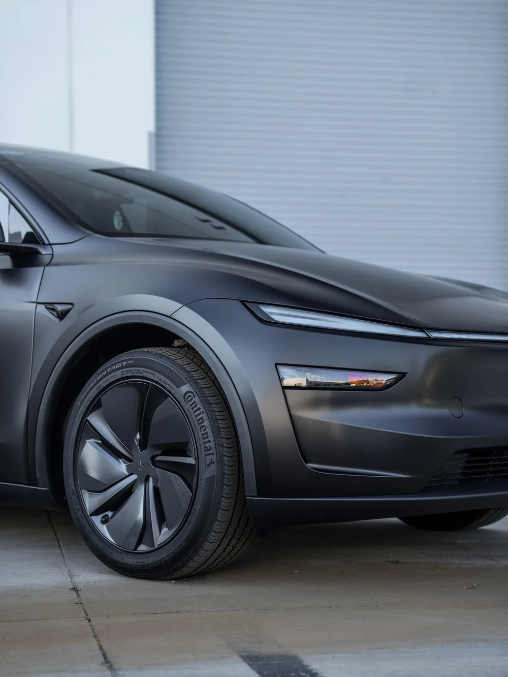 Tesla Model Y with 3M Satin Black vinyl, front wheel, hood and headlight detail
