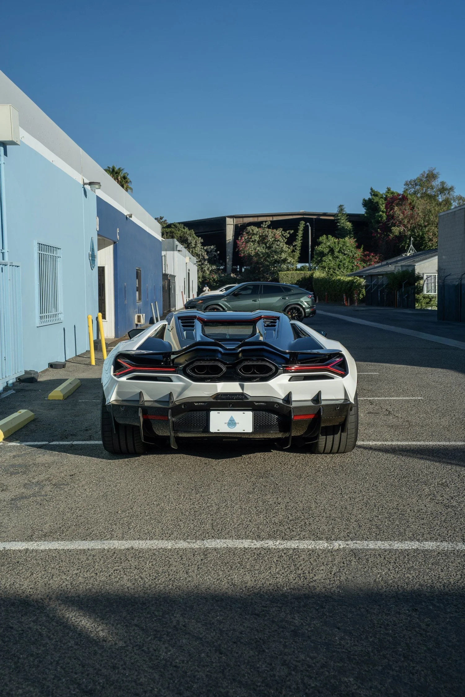 Straight-on rear view of the white Revuelto with twin exhausts and carbon rear aero.
