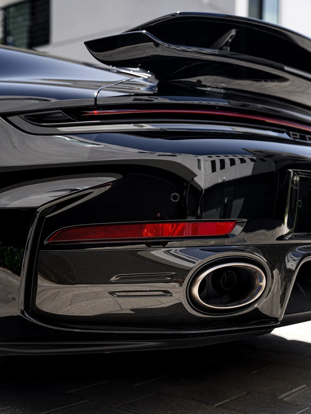 Carbon-fiber lower rear bumper trim, oval exhaust outlet and raised wing on the Turbo S.