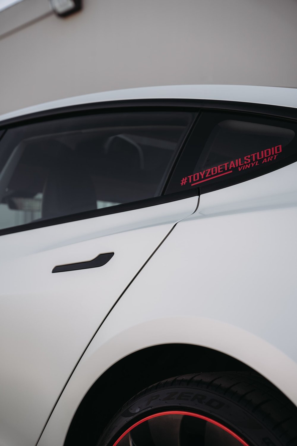 Rear side-door, quarter-window and wheel detail on the Tesla Model 3 with Satin Pearl White vinyl