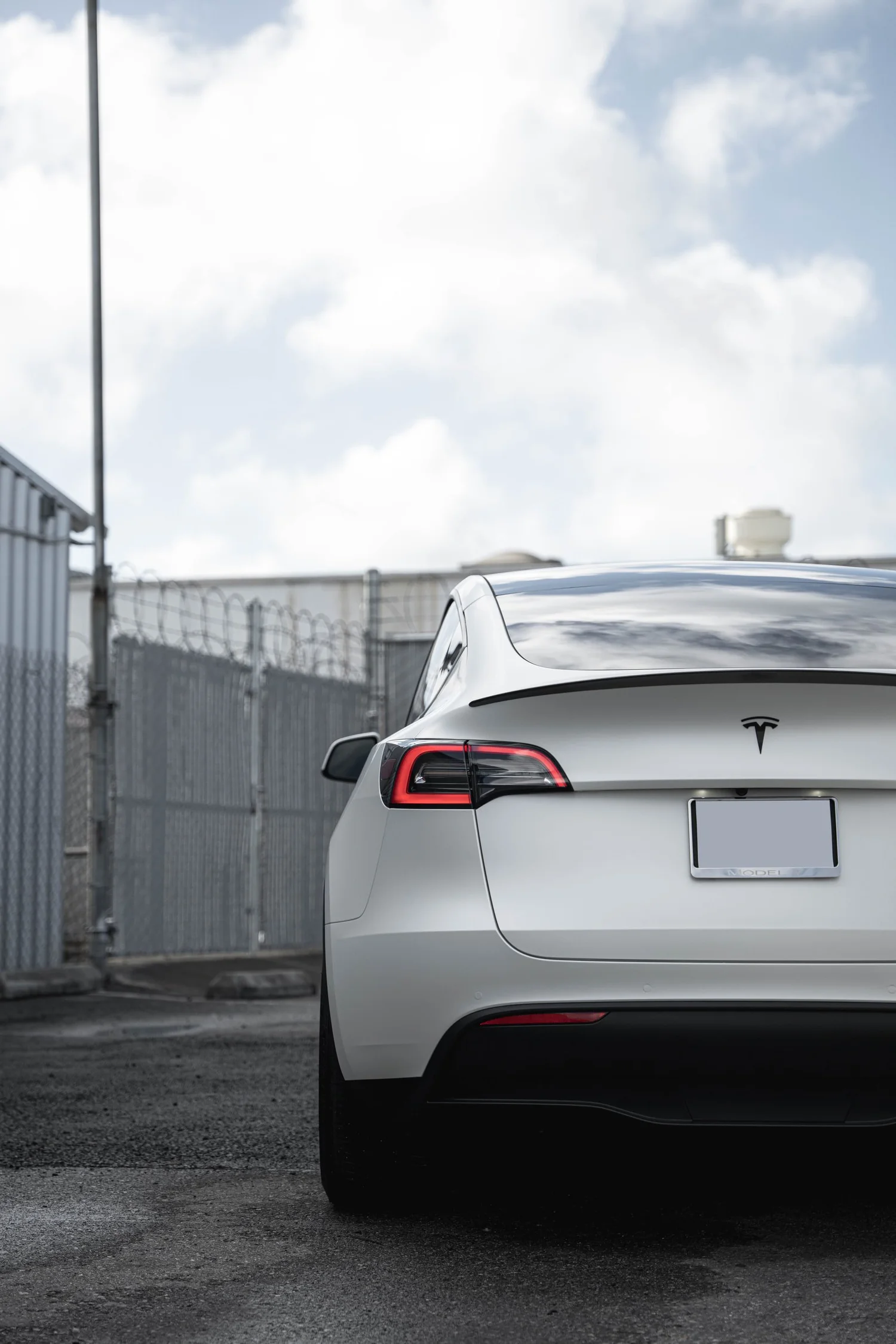 Satin Pearl White Tesla Model Y with Custom Exterior Accents after Vinyl Wrap, rear body and taillight view
