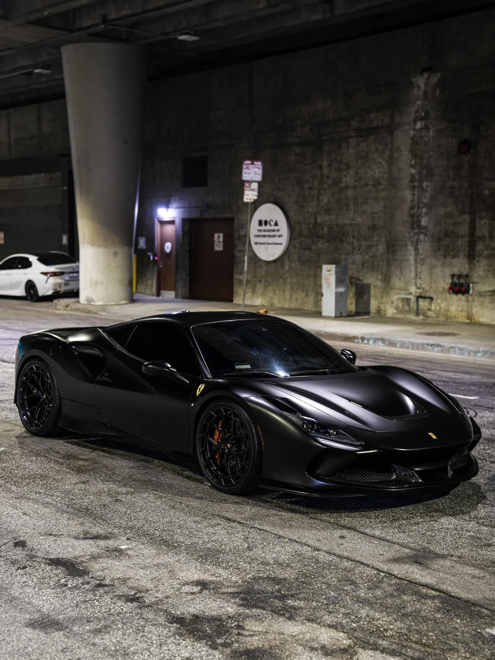 Full front three-quarter view beneath an overpass — Ferrari F8 3M Satin Black vinyl wrap project