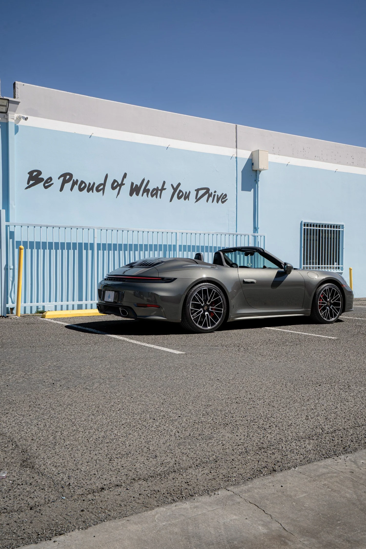 Passenger-side rear three-quarter view of the Vanadium Grey Porsche Cabriolet outside Toyz Detail Studio.