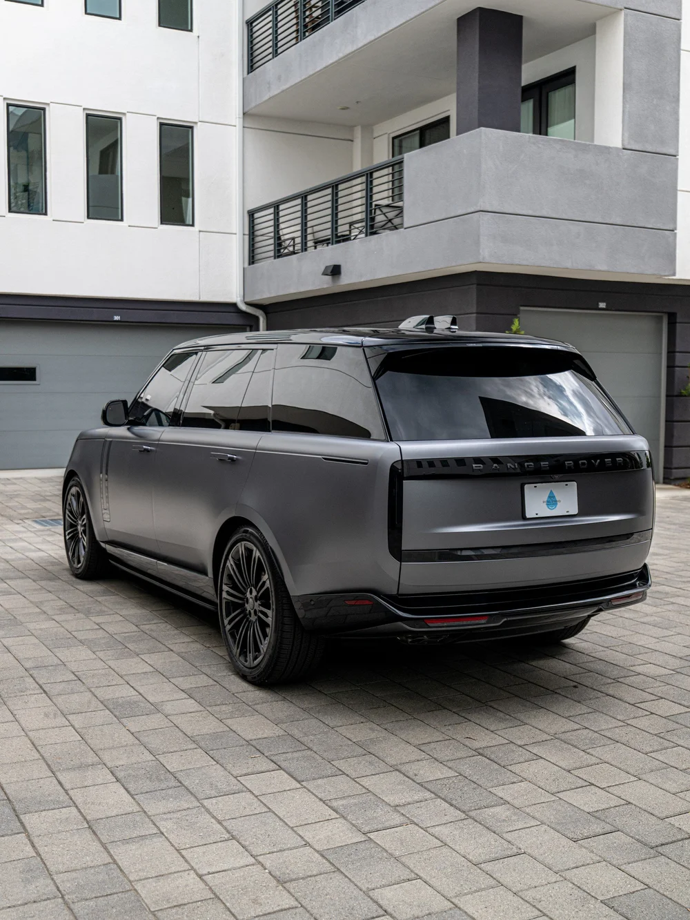 Rear three-quarter view of the satin Eiger Grey Range Rover LWB with black wheels and a long side profile.