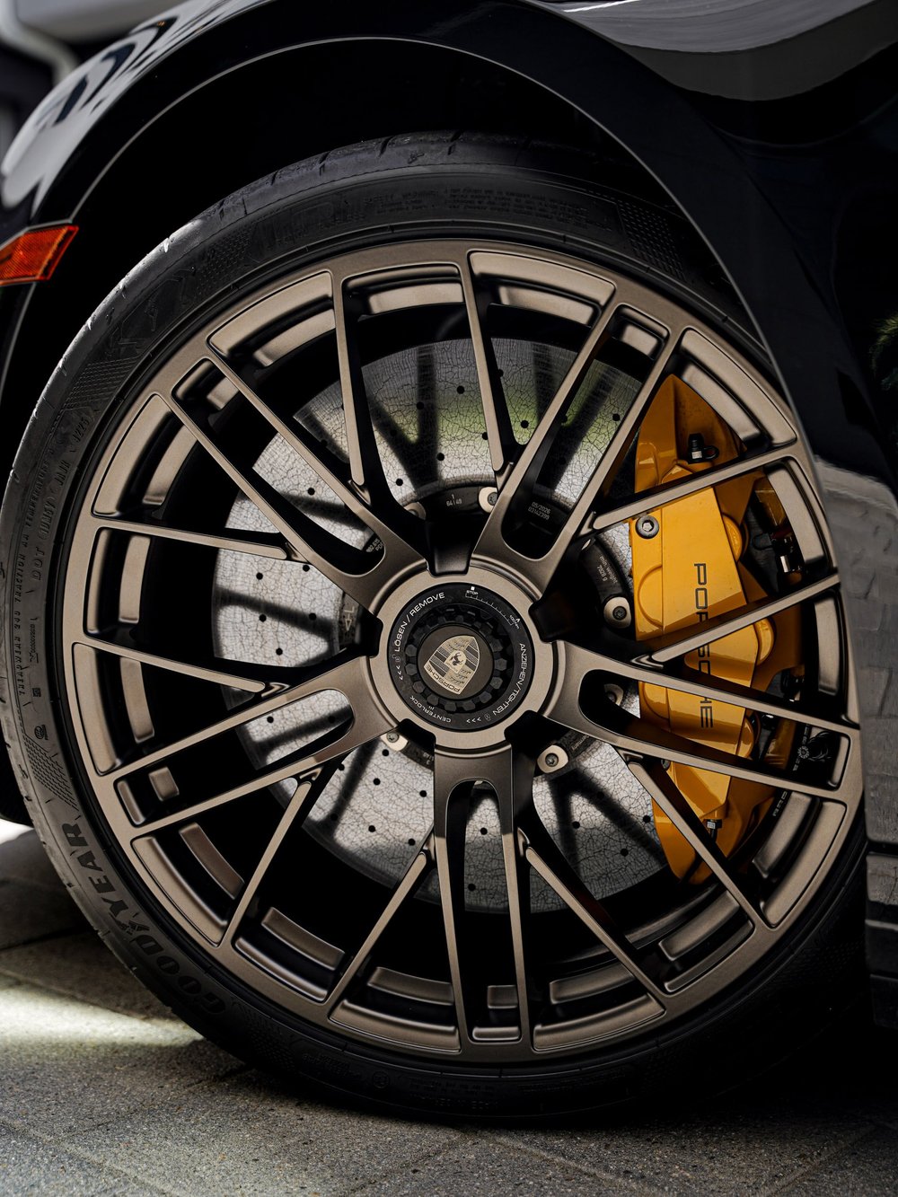 Full Turbo S wheel face with center lock, brake disc and yellow brake caliper.