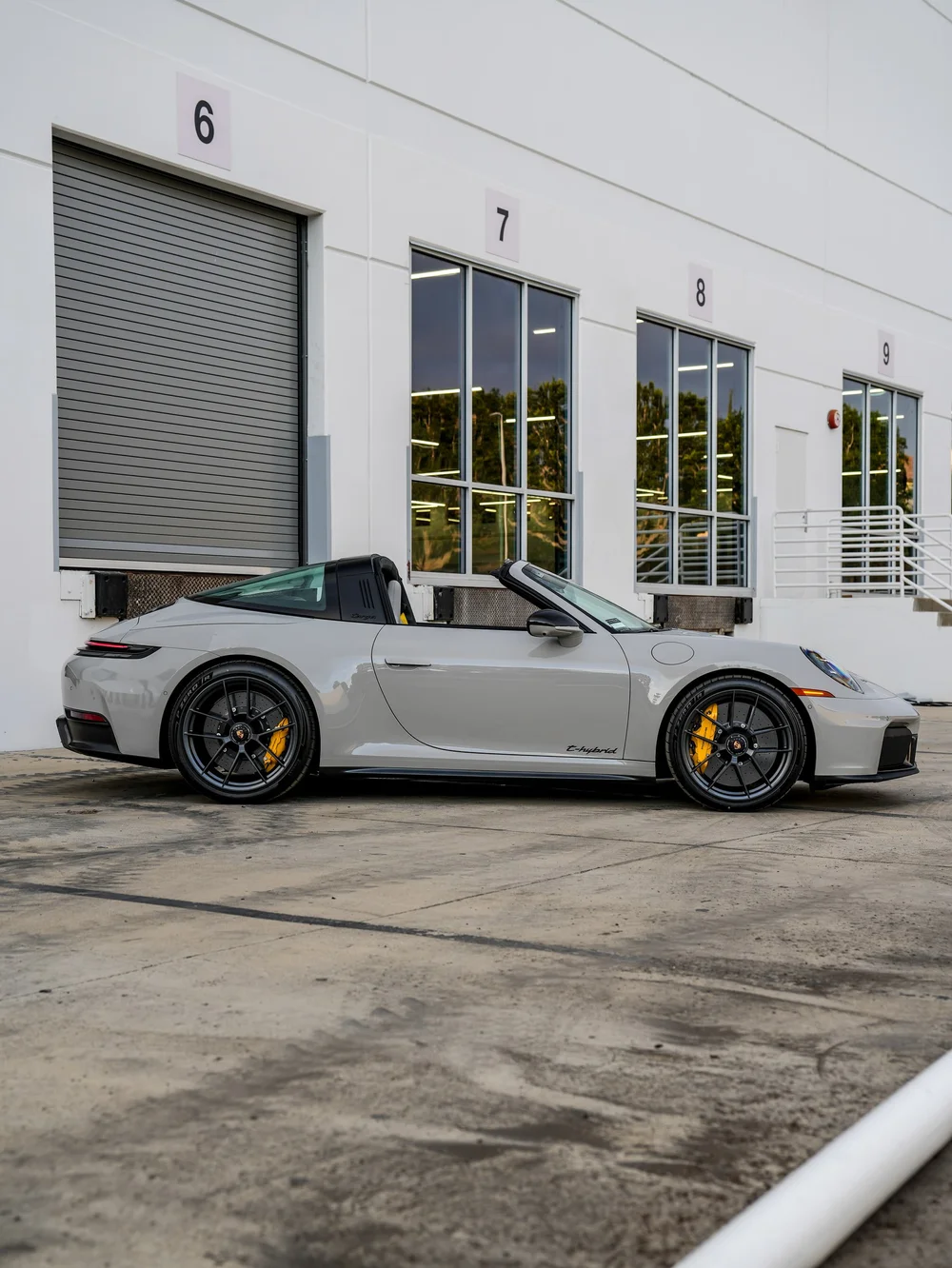 Complete side profile of the light Porsche Targa with an open roof and dark wheels