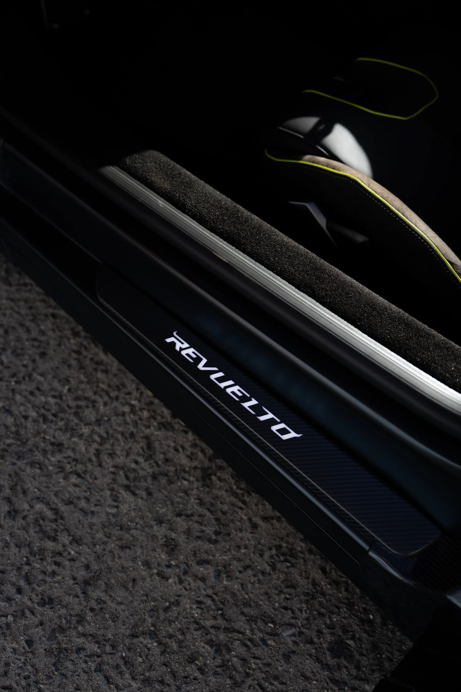 REVUELTO door-sill lettering beside the black cabin and bright contrast trim.