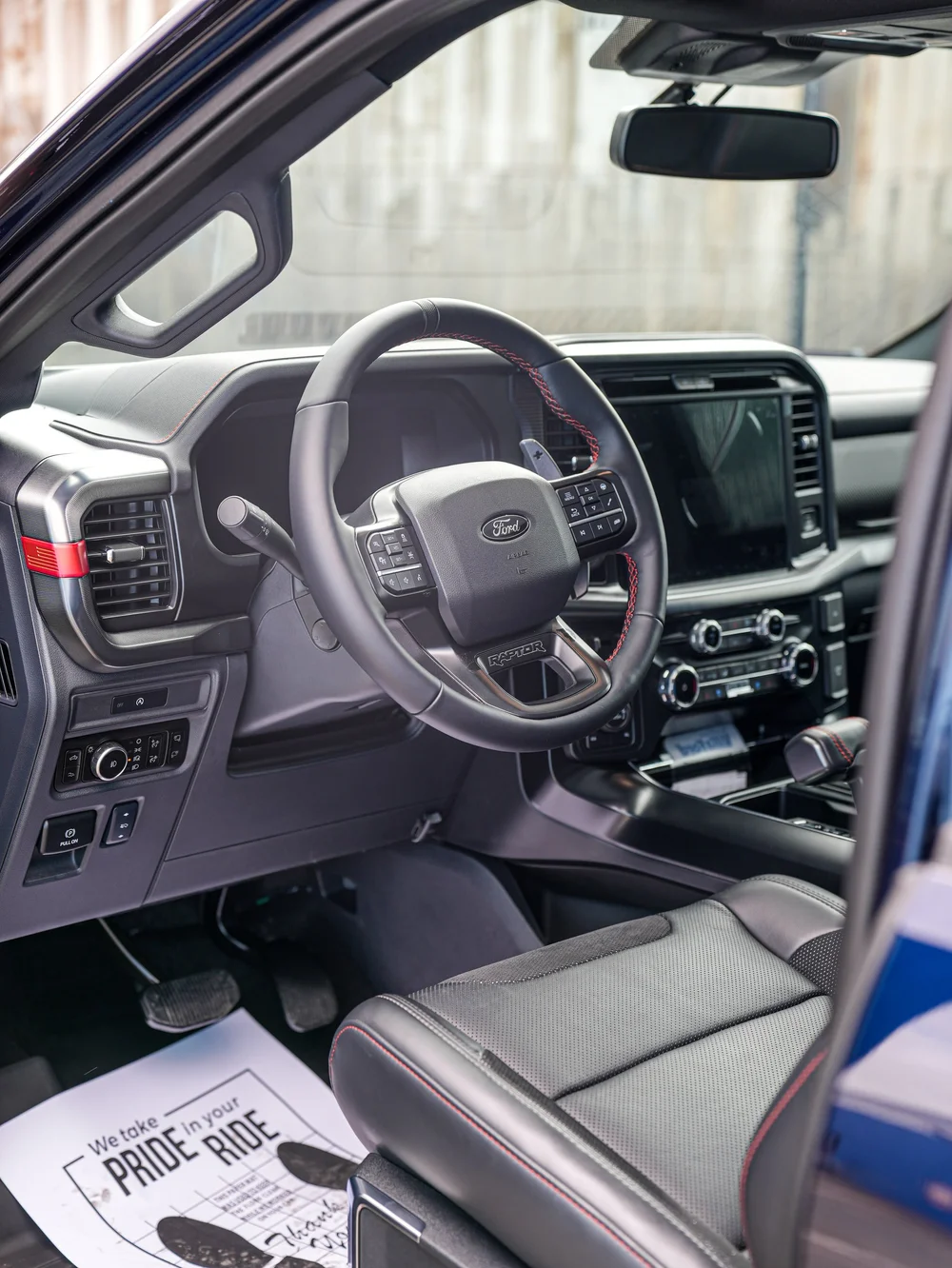 Dark Blue Ford F-150 Raptor, front cabin with steering wheel, dashboard and driver seat