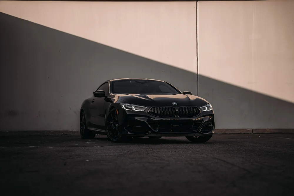 Wide front three-quarter view of the BMW M850i showing the grille, headlights and front wheel