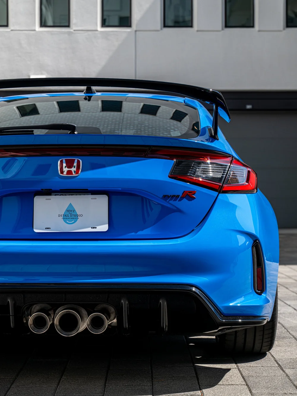 Rear hatch, taillight and wing detail on a Boost Blue Pearl Honda Civic Type R