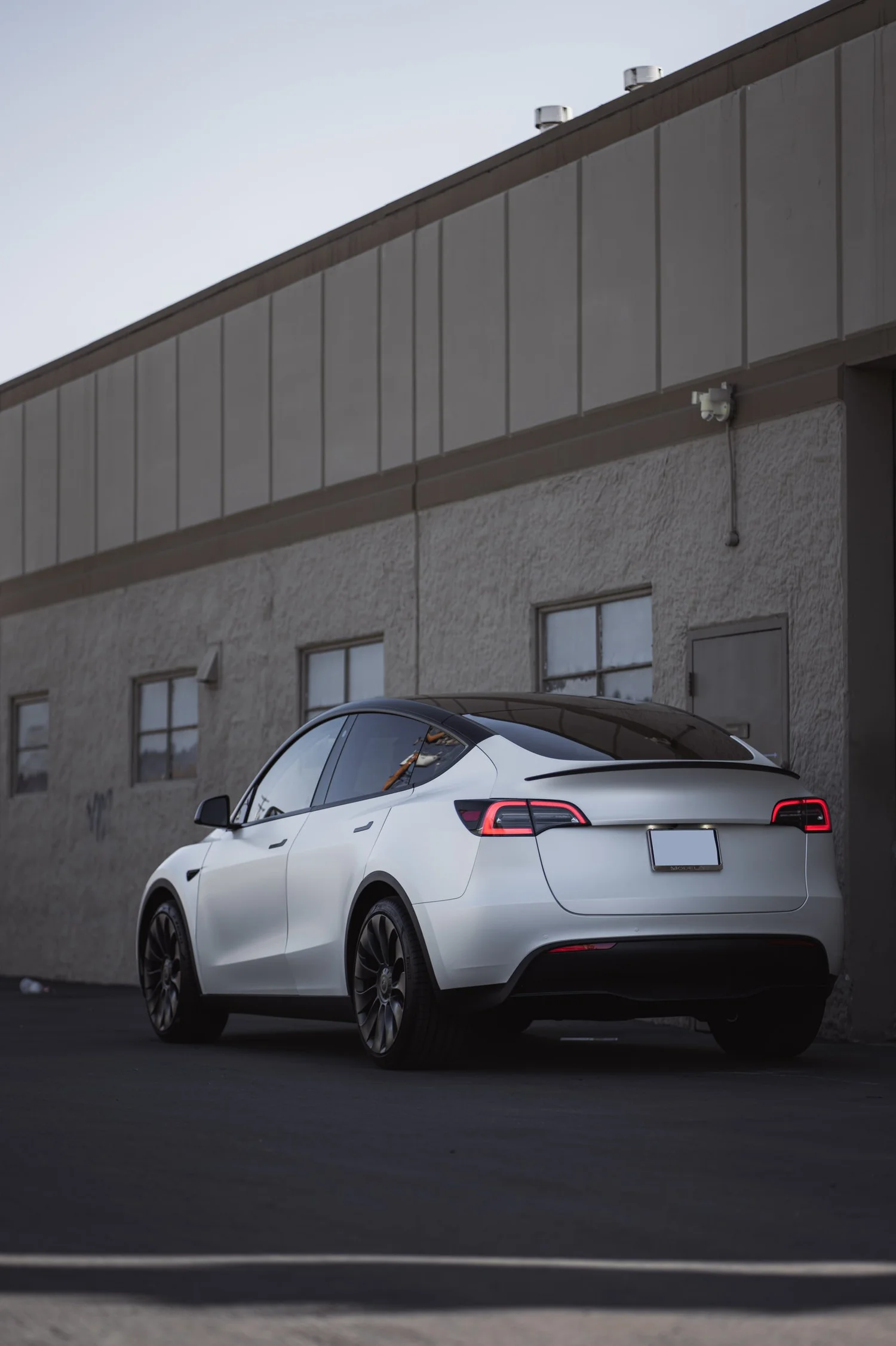 Satin Pearl White Tesla Model Y after Vinyl Wrap, rear-left three-quarter view