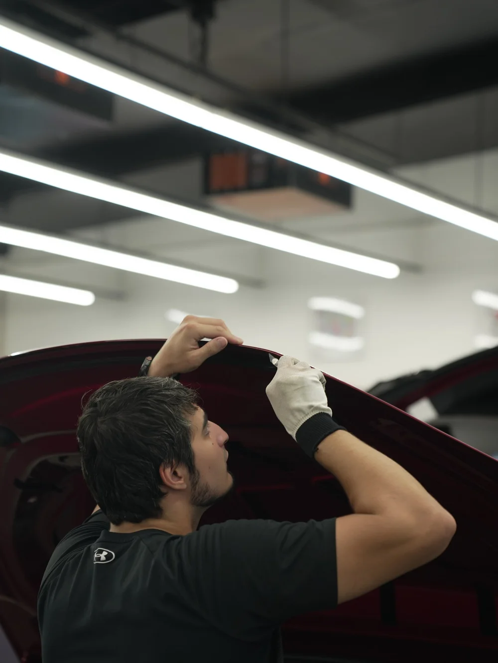 Tesla Model X PPF and XR Plus tint project, installer working near the upper window area
