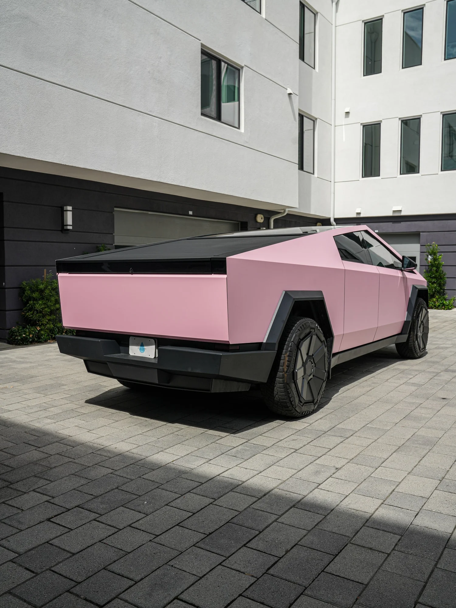 Satin Fresh Pink Tesla Cybertruck after Vinyl Wrap, rear-left three-quarter view
