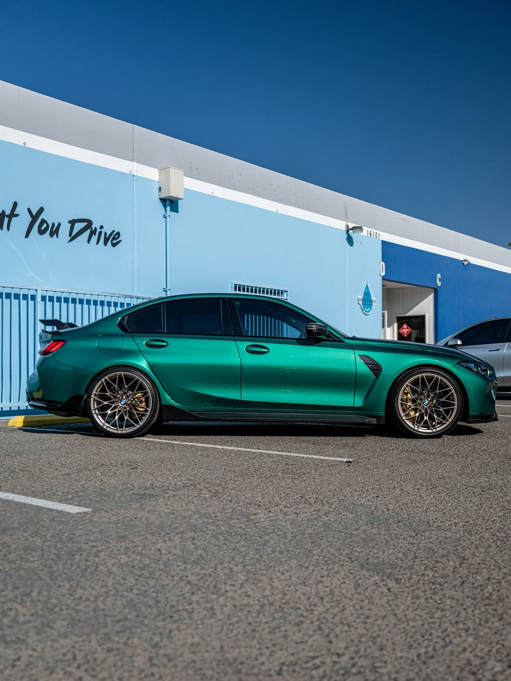 Full side profile of the Isle of Man Green manual G80 BMW M3 with carbon side-skirt extensions