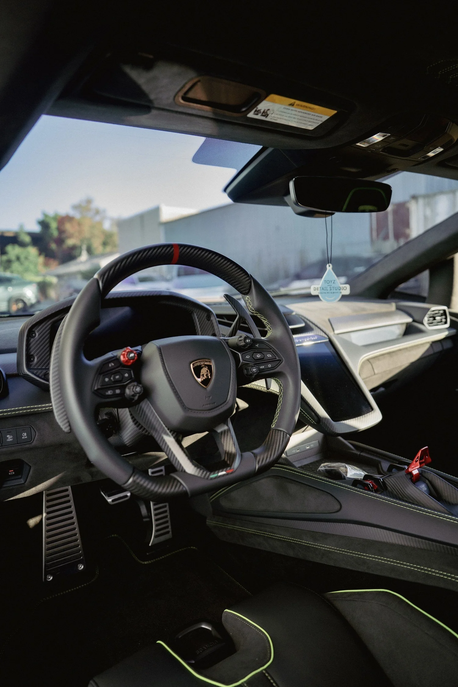 Lamborghini Revuelto driver cockpit with steering wheel and center console.