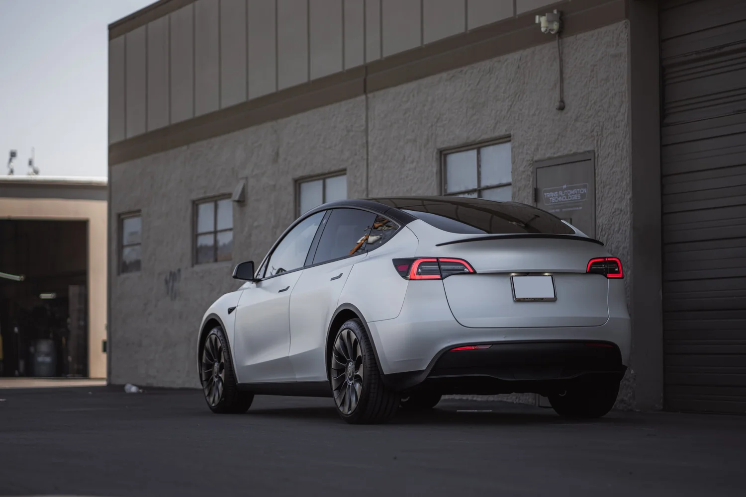 Satin Pearl White Tesla Model Y after Vinyl Wrap, rear-right three-quarter view