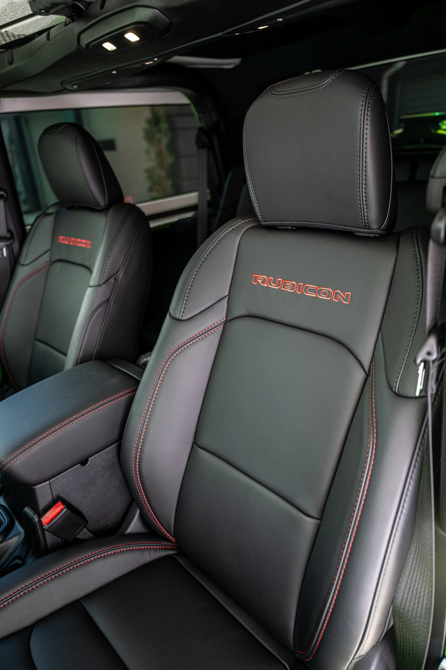 Front seats with red Rubicon embroidery and contrasting red stitching inside the Jeep Wrangler