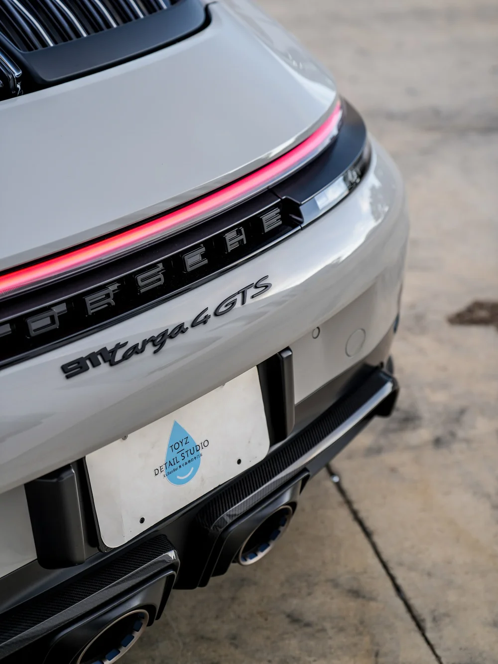 Porsche rear lettering and red light bar from an angled close view