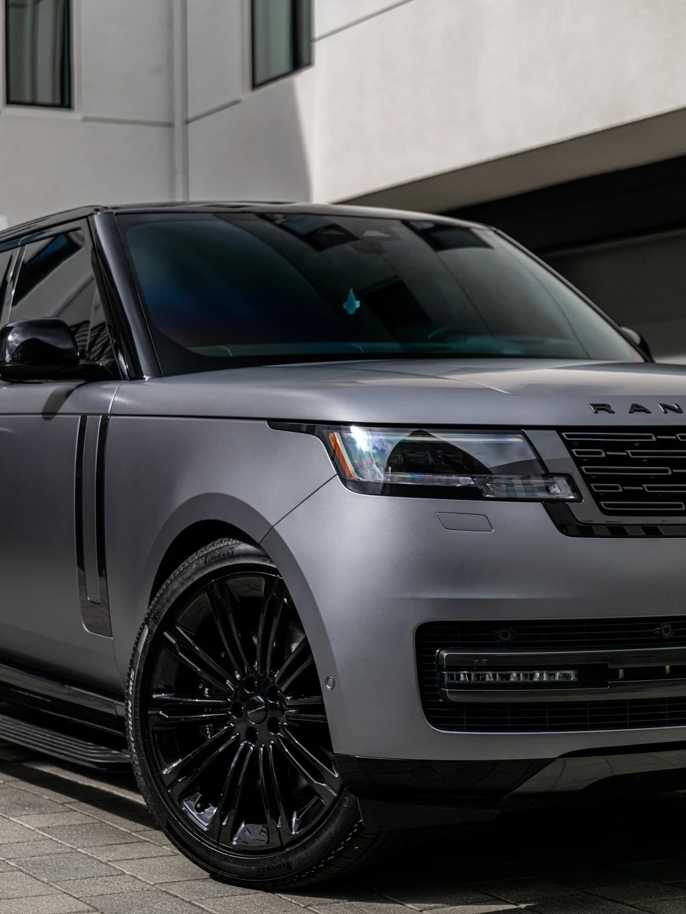Closer front three-quarter view of the Range Rover LWB, showing the satin front fender, headlight and black front wheel.