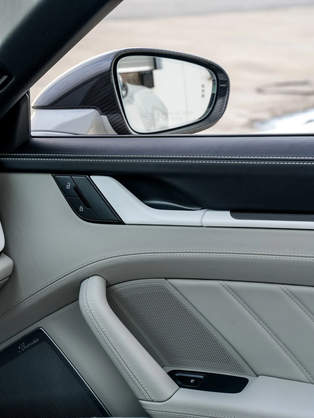 Light Porsche door trim and dark upper stitching beneath the side mirror