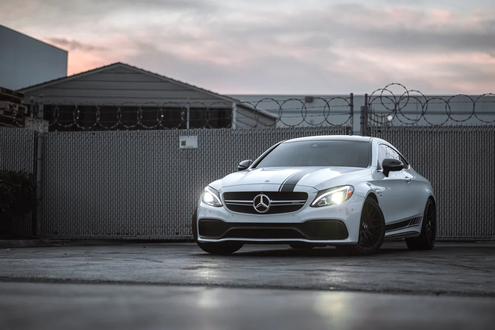 Wide front three-quarter view of the Mercedes-Benz C 63 with racing stripes on the hood