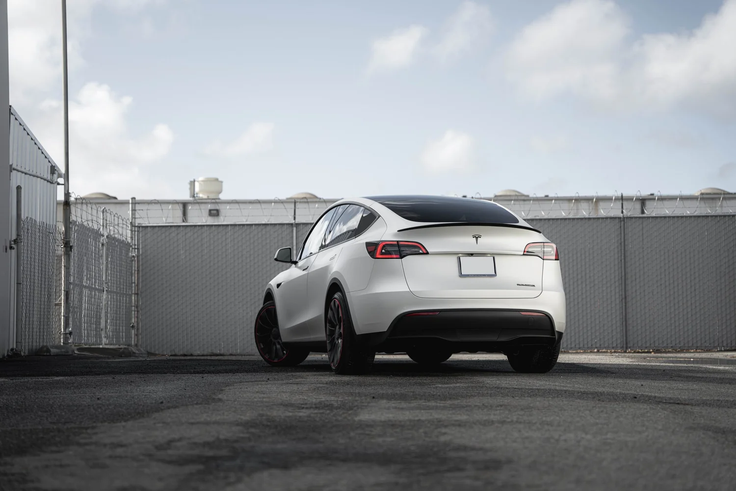 Satin Pearl White Tesla Model Y with Custom Exterior Accents after Vinyl Wrap, rear-left three-quarter view