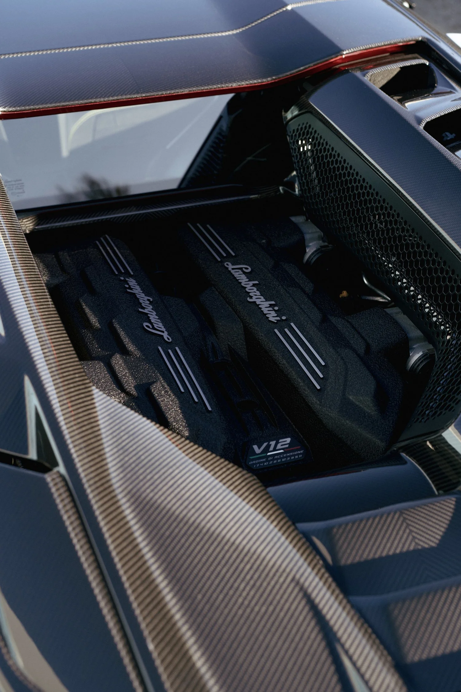 Revuelto V12 engine cover surrounded by carbon trim in the rear engine bay.