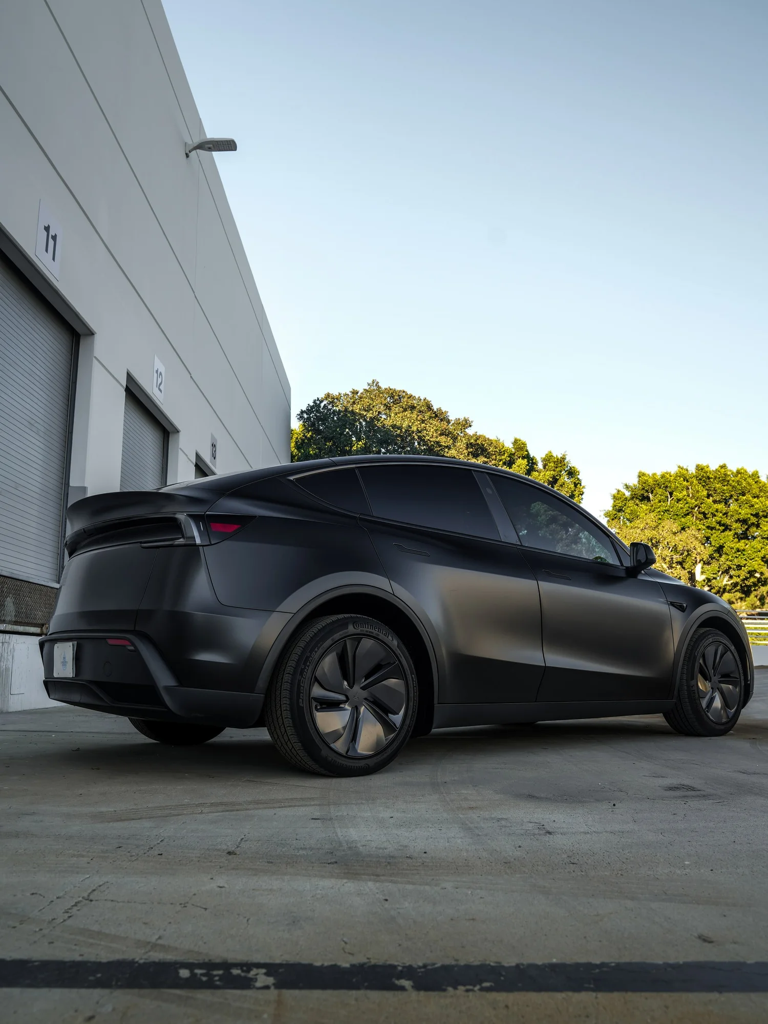 Tesla Model Y 3M Satin Black after Vinyl Wrap, rear-left three-quarter view