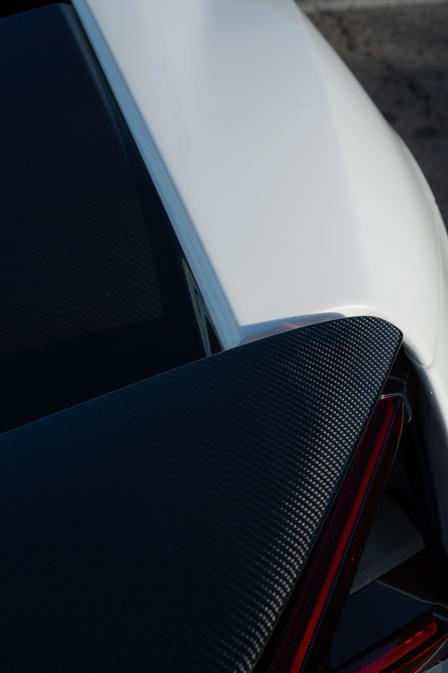 Revuelto white body panel meeting carbon rear aero beside the tail lamp.