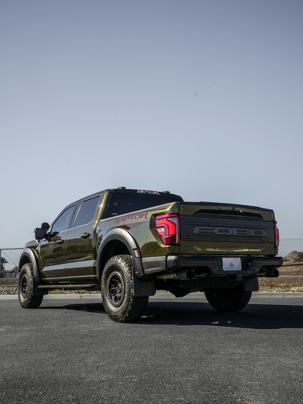 Black Ford F-150 Raptor, rear three-quarter view showing the complete truck